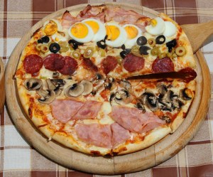A pizza with various toppings. Image: Pizza Masetti Craiova, Romania (Flickr)  [CC BY 2.0 (http://creativecommons.org/licenses/by/2.0)], via Wikimedia Commons.